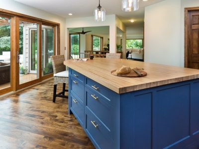 A contemporary open concept kitchen renovation remodeling featuring a center island, hardwood floor and quartz counter.