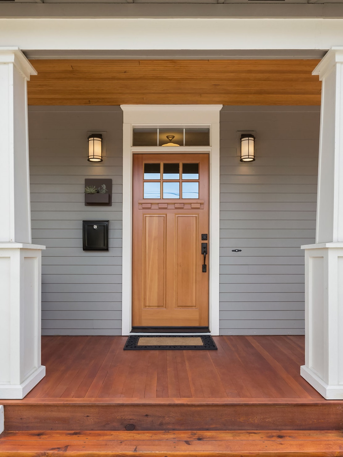 Facade of home with covered porch and door About Acme Supply Doors